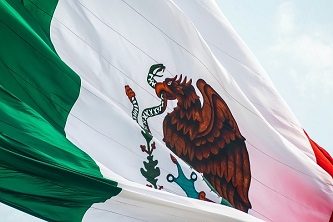 An image of the Mexican flag unfurled in the air