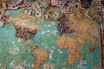 Map of the world with currency bills from various countries