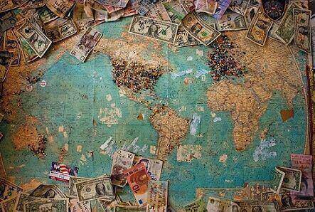 Map of the world with currency bills from various countries