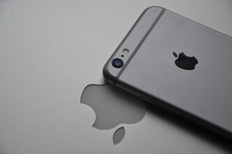 An image of an iPhone with the Apple logo in the background