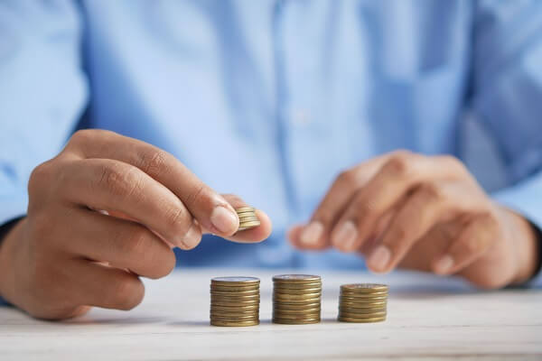 A person moving coins from one stack of coins to another