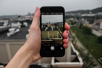 An image of a traveler taking a picture of a city location with their mobile phone