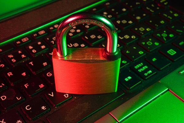 A padlock placed on a green light laptop keyboard