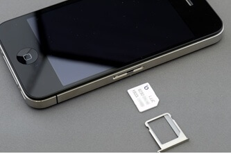 An image of an iPhone with its SIM card and SIM tray pulled out