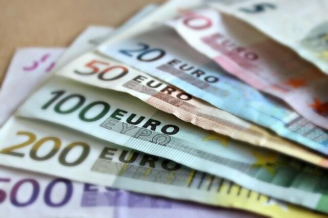 An assortment of Euro currency bills laid out on a table in fan formation