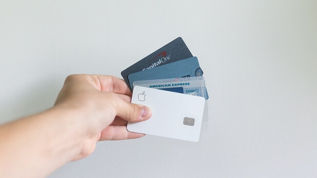 A person holding white and blue magnetic credit and debit cards in their hand