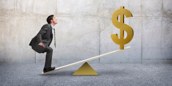 A see saw with a person on one end and a US Dollar symbol on the other end