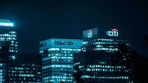 High rise buildings during night time with logos of Citibank and HSBC Bank