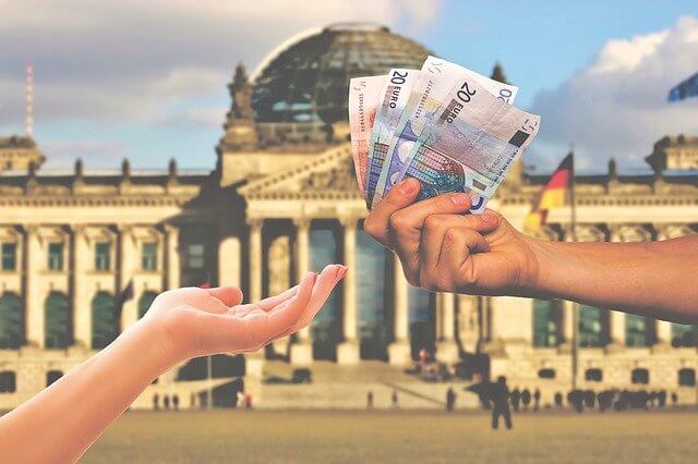 A graphic of one hand passing money to another with a building in the background