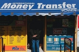 Street scene of a man waiting in line at a money transfer shop in a notoriously dodgy place in London