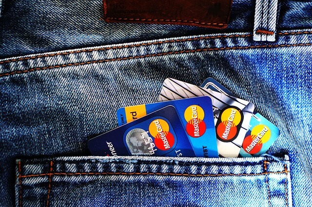 A collection of credit cards in the rear pocket of blue jeans