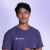 An image of a smiling young man with a Profee t-shirt on and a mobile phone in hand