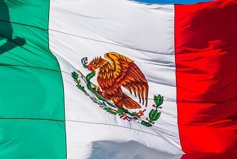An image of the flag of Mexico waving in the air