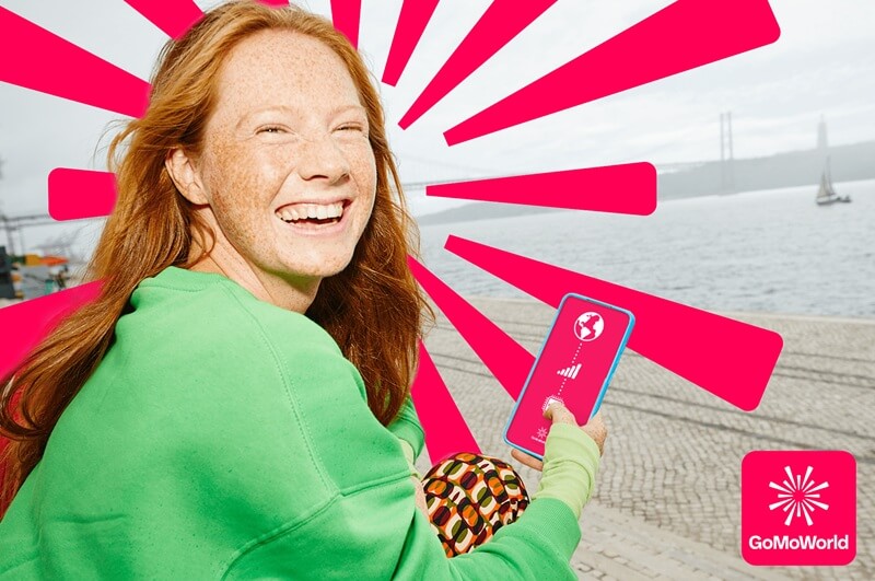 An image showing a happy girl with a GoMoWorld international eSIM with GoMoWorld logo in the background